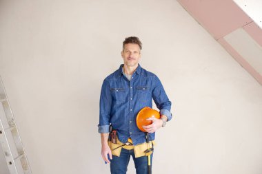 El Güvenlik kask duran inşaat alanında tutan orta yaşlı inşaat adam portresi. 