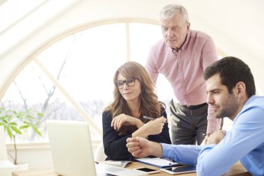 İş takım çalışma toghether ofiste. Grup ofis masası oturma ve finansal veri analiz edilirken dizüstü kullanarak iş adamları. 