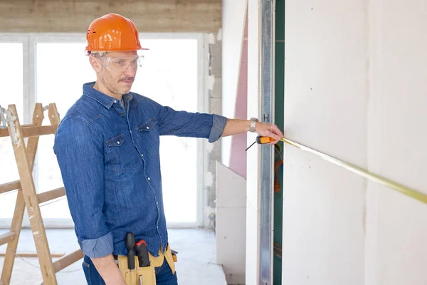 Den Handyman Med Hjälp Ett Måttband Medan Arbetar Byggarbetsplatsen Reparatör — Stockfoto