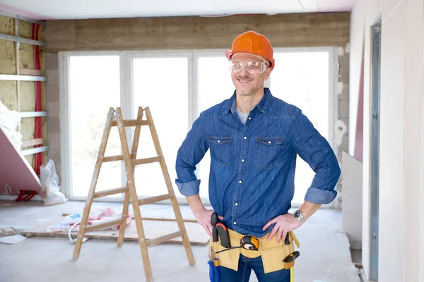 Portrait Smiling Handyman Standing Hands His Hips Construction Site — Stock Photo, Image