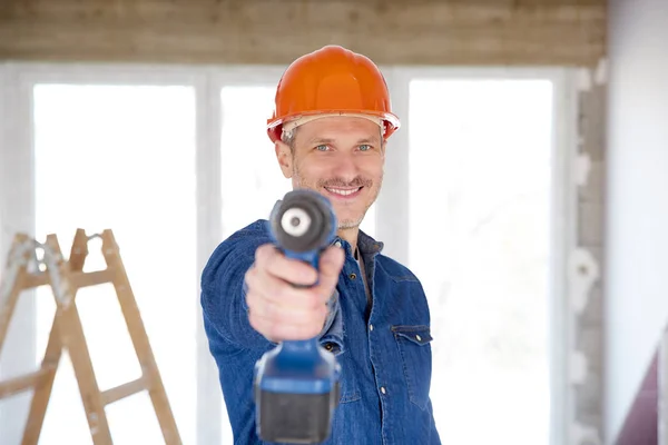 Leende Handyman Bära Skyddshjälm Och Håller Borren Handen Stående Byggarbetsplats — Stockfoto