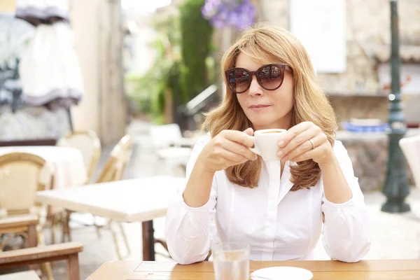 Çekici orta yaşlı kadın onun espresso café'de içme portresi.