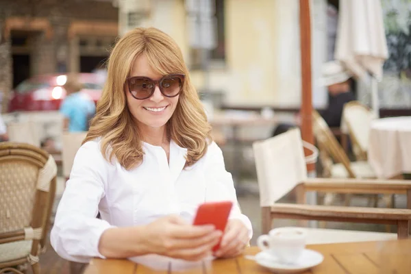 微笑迷人的女人在户外咖啡馆放松的肖像和短信 — 图库照片