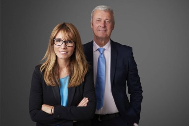 Bir çekici orta yaşlı işkadını ve bir exectuive profesyonel adam izole arka plan ayakta.