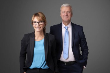 Bir çekici orta yaşlı işkadını ve bir exectuive profesyonel adam izole arka plan ayakta.