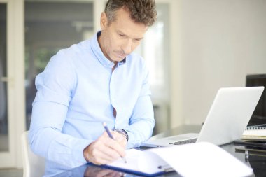 Ofis Masası oturma ve onun bilgisayar kullanarak forması giyen işadamı orta yaşlı.  