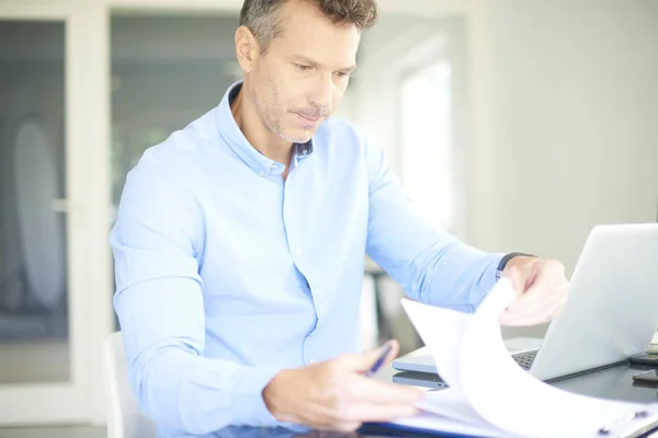 中年商人坐在办公桌前穿着衬衣 用电脑 — 图库照片