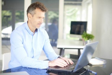 Ofis Masası oturma ve iş projede çalışan süre onun dizüstü bilgisayarda yazarak mali danışmanı işadamı kadeh.