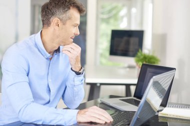 Laptop önünde oturan ve düşünceli arıyorum yeni proje üzerinde çalışırken düşünme işadamı kadeh. 