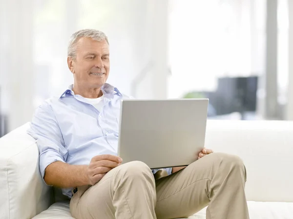 Tiro Homem Idoso Usando Seu Laptop Enquanto Relaxa Casa — Fotografia de Stock