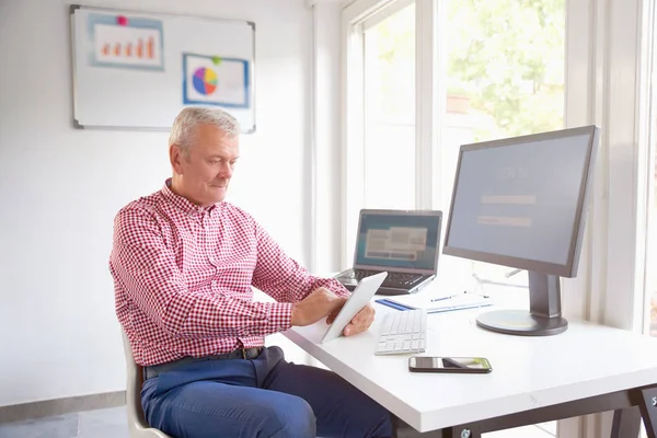 Gerente Vendas Sênior Usando Tablet Digital Enquanto Sentado Mesa Escritório — Fotografia de Stock