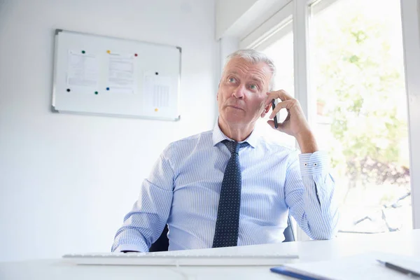 Senior Affärsman Sitter Vid Skrivbord Och Talar Hans Mobiltelefon Äldre — Stockfoto