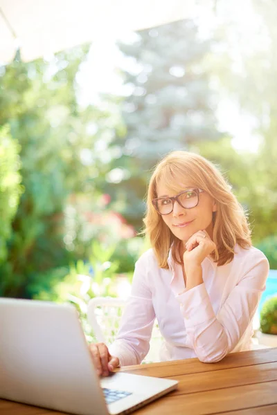 Portret Uśmiechający Się Średniej Wieku Kobieta Pomocą Swojego Laptopa Siedząc — Zdjęcie stockowe