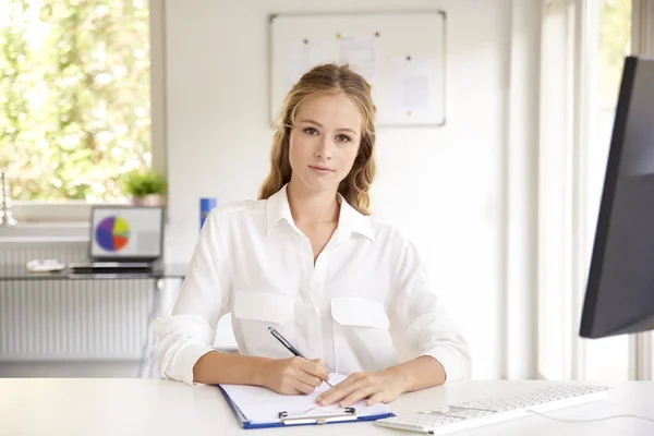 Portrait Smiling Young Businesswoman Sitting Office Desk Doing Some Paperwork — Stock Photo, Image