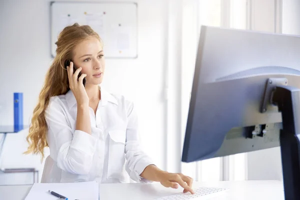 Biri Ile Onu Cep Telefonundan Konuşuyor Ofiste Otururken Bilgisayarını Kullanarak — Stok fotoğraf