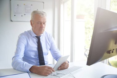 Ofis Masası oturma ve yatırım stratejisi üzerinde çalışma sırasında dijital tablet kullanarak bir üst düzey banka memuru vurdu. 