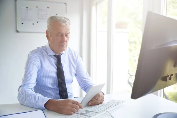 Aufnahme Eines Leitenden Bankangestellten Mit Digitalem Tablet Während Schreibtisch Sitzt — Stockfoto