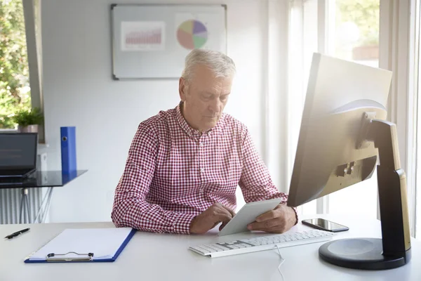 Empresário Sênior Usando Seu Tablet Digital Enquanto Senta Mesa Escritório — Fotografia de Stock