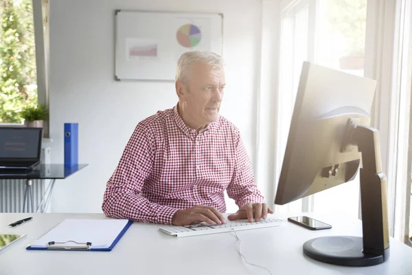 Tiro Vendedor Sênior Sentado Mesa Escritório Digitando Teclado Enquanto Trabalhava — Fotografia de Stock