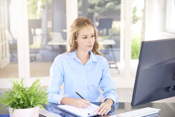 Fotografía Una Joven Vendedora Sentada Frente Portátil Tomando Notas Mientras — Foto de Stock