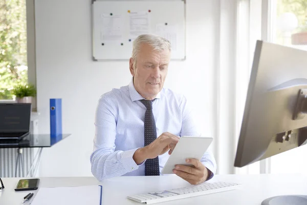 Tiro Empresário Sênior Usando Tablet Digital Enquanto Trabalhava Escritório — Fotografia de Stock