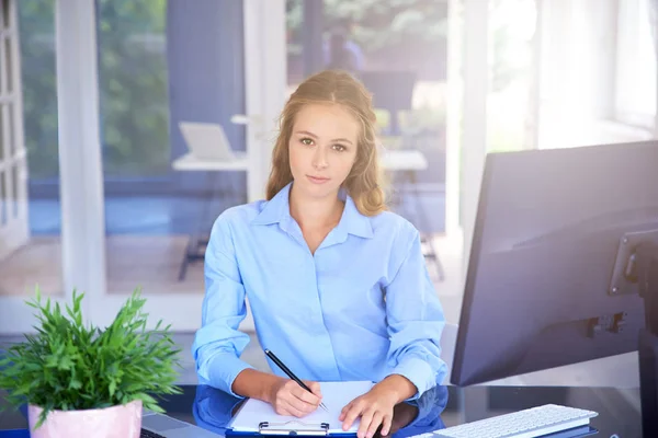 Hermosa Mujer Joven Tomando Notas Mientras Está Sentada Frente Computadora —  Fotos de Stock