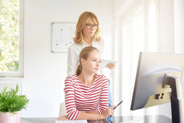 Schot Van Jonge Verkoopassistent Zit Laptop Terwijl Midden Leeftijd Zakenvrouw — Stockfoto