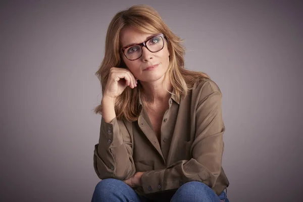 Retrato Estudio Una Mujer Mediana Edad Sentada Frente Fondo Gris —  Fotos de Stock