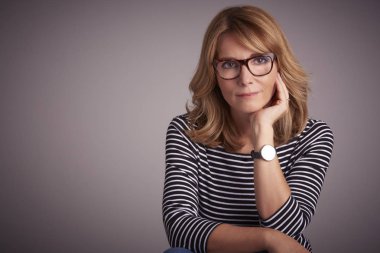 Stüdyo gri arka plan karşı oturan düşünme Olgun kadın portresi.