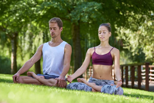 在户外练习瑜伽时 年轻夫妇坐在莲花姿势和冥想的全长镜头 — 图库照片