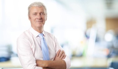 Kendinden emin bir eski profesyonel adam ofiste ayakta portresi.