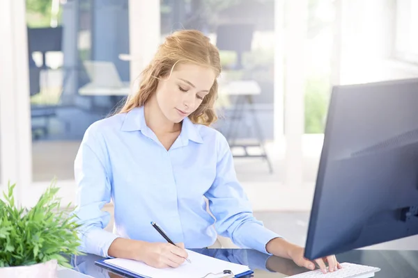 Fotografía Una Joven Vendedora Sentada Frente Portátil Tomando Notas Mientras — Foto de Stock