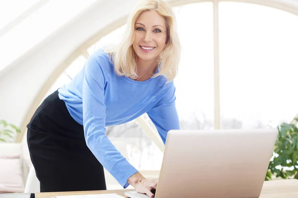 Uśmiechający Się Piękne Dojrzałe Bizneswoman Wpisując Laptopie Patrząc Kamery Uśmiechając — Zdjęcie stockowe