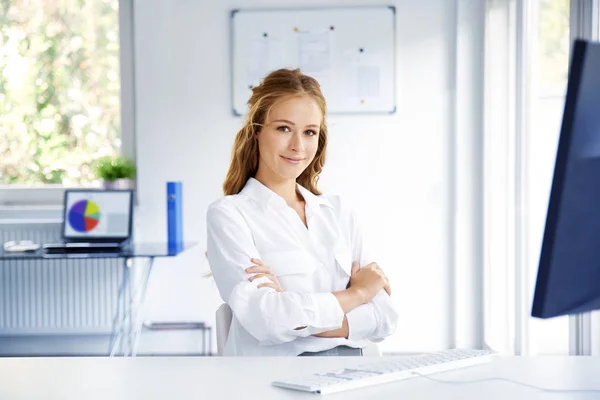 Lächelnde Junge Verkäuferin Mit Verschränkten Armen Die Vor Dem Computer — Stockfoto