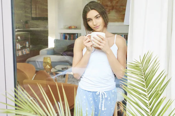 Bir Fincan Kahve Pencerenin Arkasında Ayakta Rüya Pijama Giymiş Genç — Stok fotoğraf