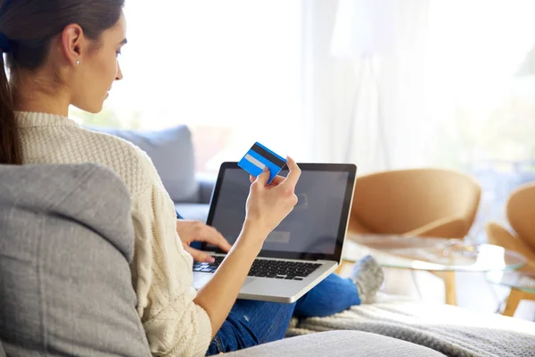 妇女在家中网上购物时手持银行卡和使用笔记本电脑的后视照片 — 图库照片
