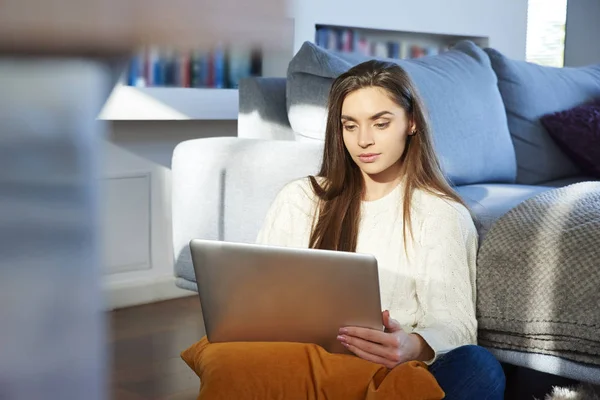 Retrato Pensar Jovem Mulher Usando Seu Laptop Enquanto Sentado Sofá — Fotografia de Stock