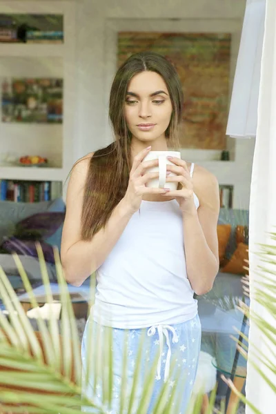 Bir Fincan Kahve Pencerenin Arkasında Ayakta Rüya Pijama Giymiş Genç — Stok fotoğraf