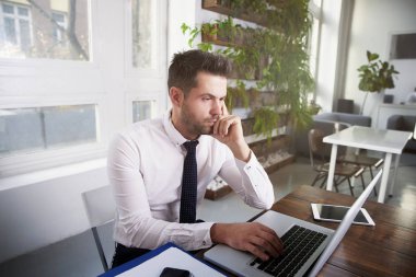 Düşünceli ise ofis masa başında oturan ve dizüstü bilgisayarda yazarak arıyor işadamı portre vurdu.