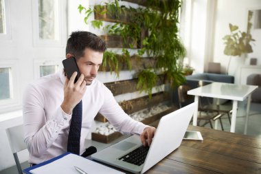 cep telefonundan konuşuyor ve laptop ofiste çalışan düşünme mali Yardımcısı işadamı.