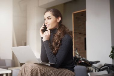 Biriyle konuşurken onu cep telefonundan ofiste oturma ve çalışma genç iş kadını vurdu. 