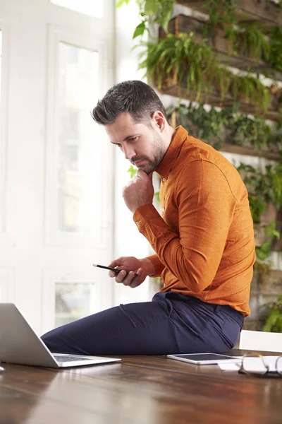 Shot Thinking Businessman Sitting Office Desk Using His Mobile Phone — Stock Photo, Image