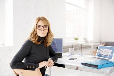 Ofis Masası oturma ve geriye dönüp baktığımda kameraya gülümseyen çekici olgun işkadını, yakın çekim portre vurdu. 