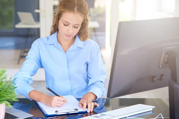 Strzał Młoda Kobieta Sprzedaży Siedząc Laptopa Dokonywanie Notatek Podczas Pracy — Zdjęcie stockowe