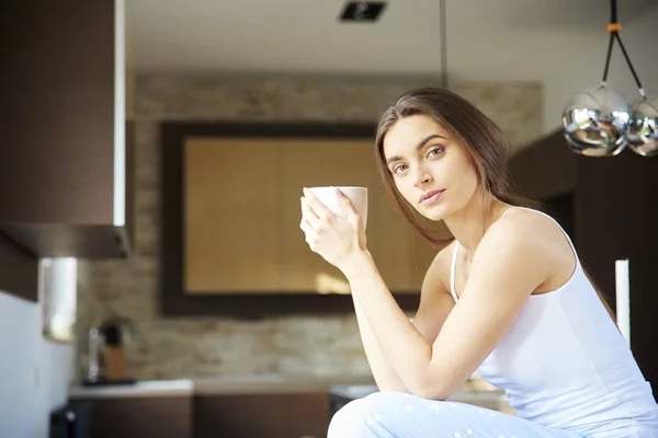 パジャマを着て 家でリラックスしながら彼女の朝のお茶を飲む若い女性の肖像画のショット — ストック写真