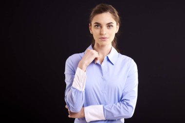 Kameraya bakarak ve izole siyah uygunluğunu, dururken gülümseyen çekici genç kadın portre çekim. 