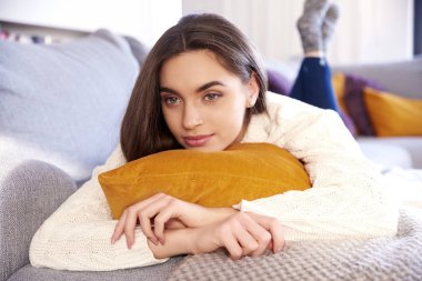 Evde kanepede yatan ve düşünceli arıyorum düşünme genç kadın portre çekim.