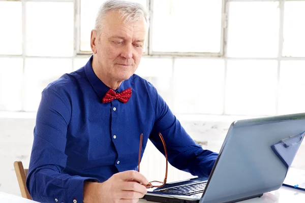 Älterer Geschäftsmann arbeitet im Büro am Laptop — Stockfoto