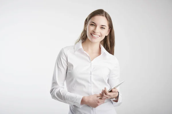 工作室拍摄的年轻女商人 她手捧数码平板电脑 站在孤立的白色背景上 带着牙齿的微笑 — 图库照片