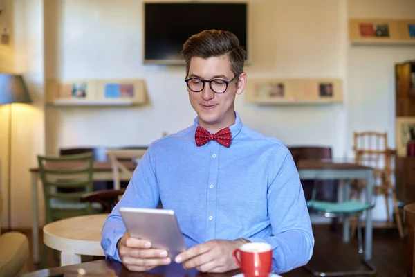 Masada Otururken Dijital Tabletini Kullanırken Nedensel Kıyafetler Giyen Genç Adamın — Stok fotoğraf